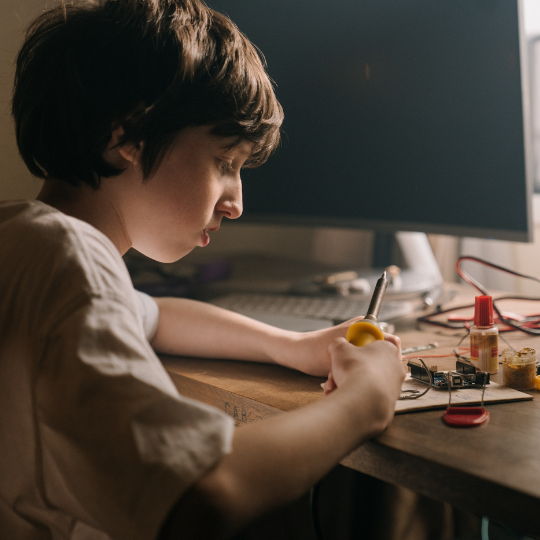 73_9282_05Jun2023134138_Young boy holding electronics tools 540px.png